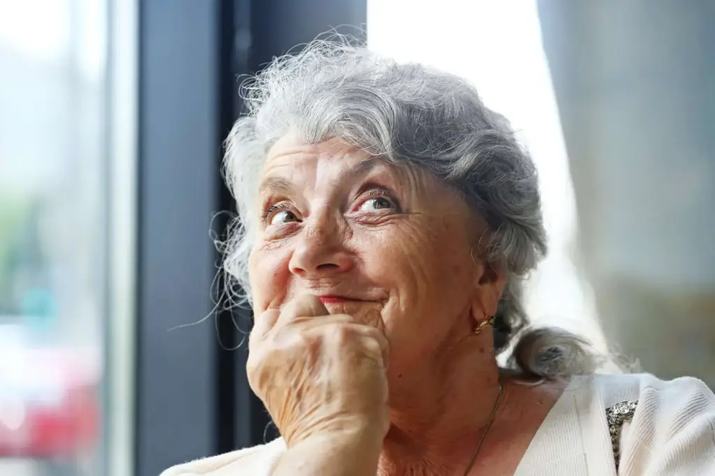 lächelnde alte Frau, die nach oben rechts schaut