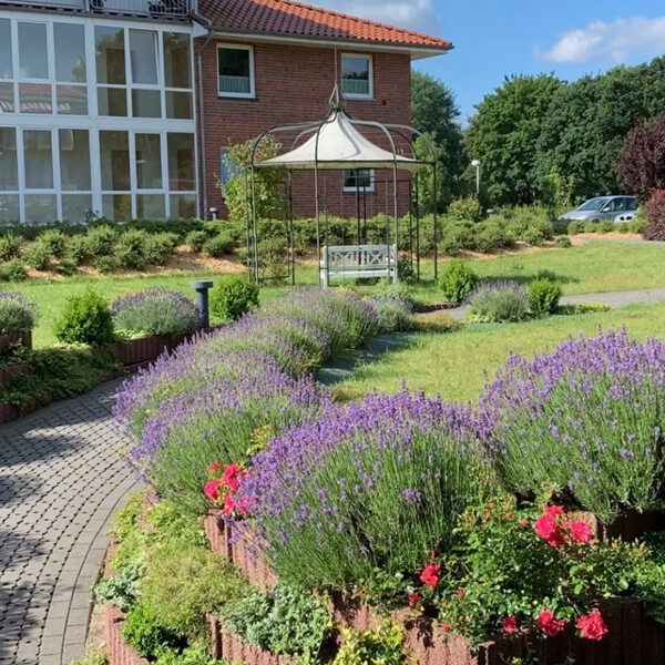 Garten der Einrichtung im Lavener Weg mit schöner Bepflanzung und Wege zu einem Pavillon